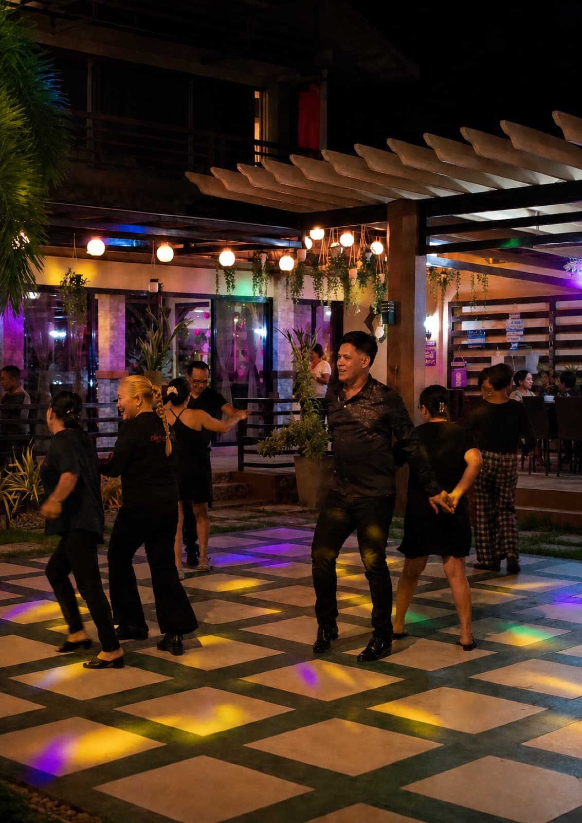 Guests dancing on the open-air floor under the lights on a Friday night